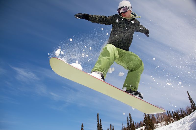 Сноубордист в полете над горой