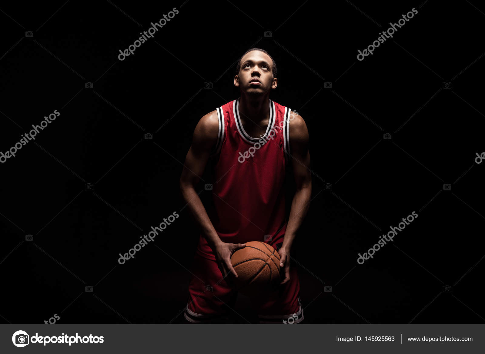 Баскетболист в красной форме на черном фоне